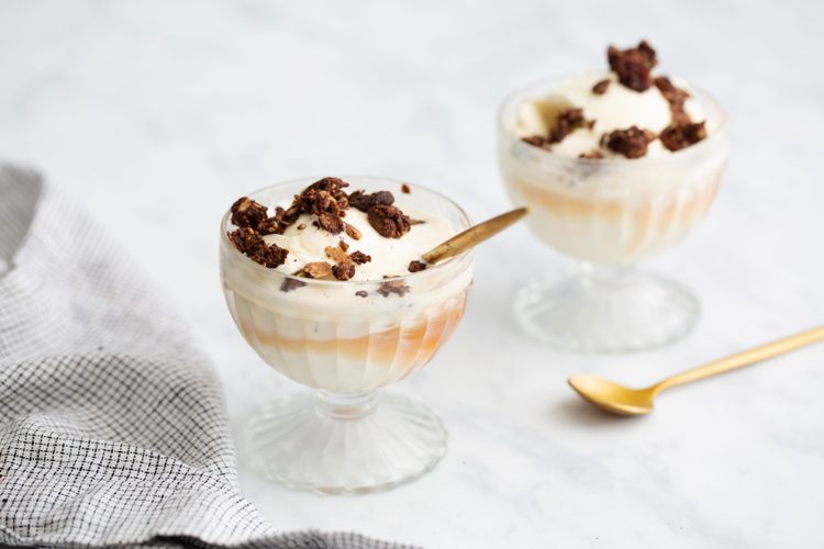 a yogurt parfait with granola and a gold spoon