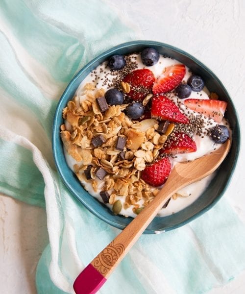 Bowl of yogurt with Coconut GF Granola, chia seeds, strawberries and blueberries